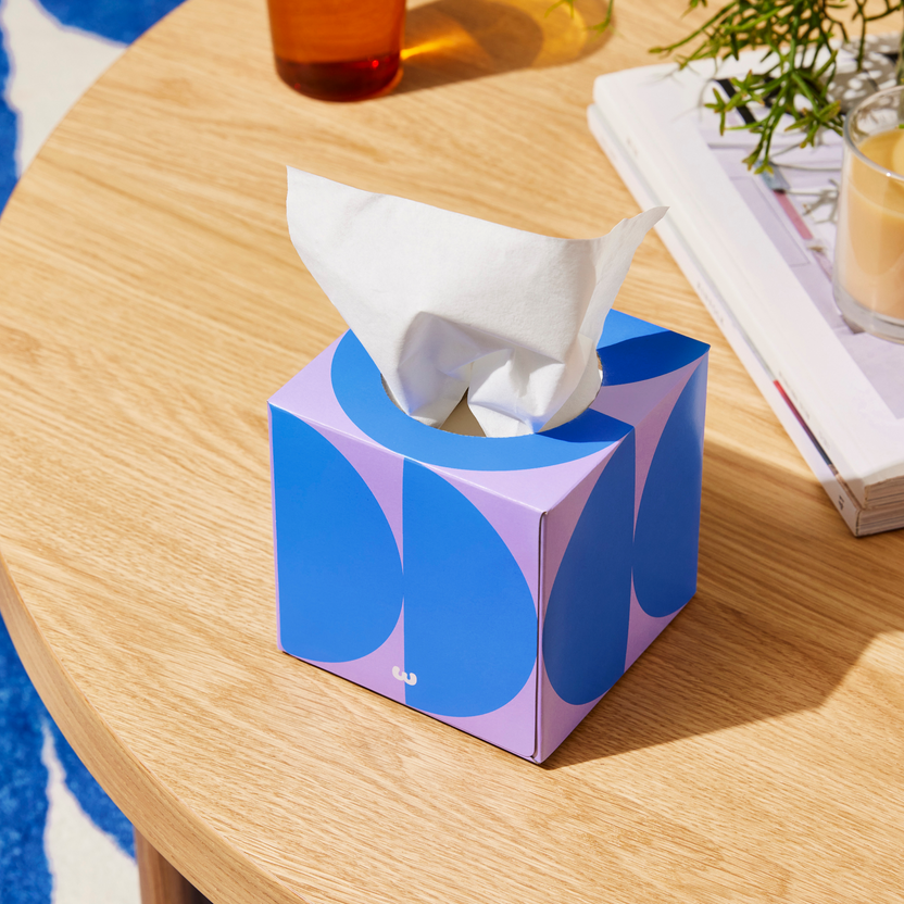 Who Gives a Crap tissue box on table with books and candle Who Gives a Crap tissue box on table with books and candle