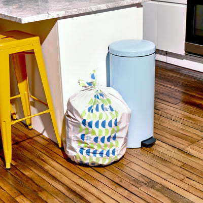 Trash bags sitting next to a bin