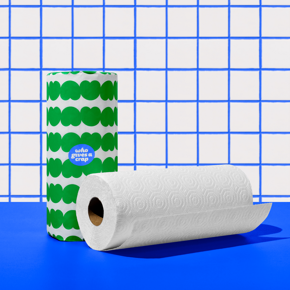 Two rolls of Who Gives a Crap paper towel against green and white background