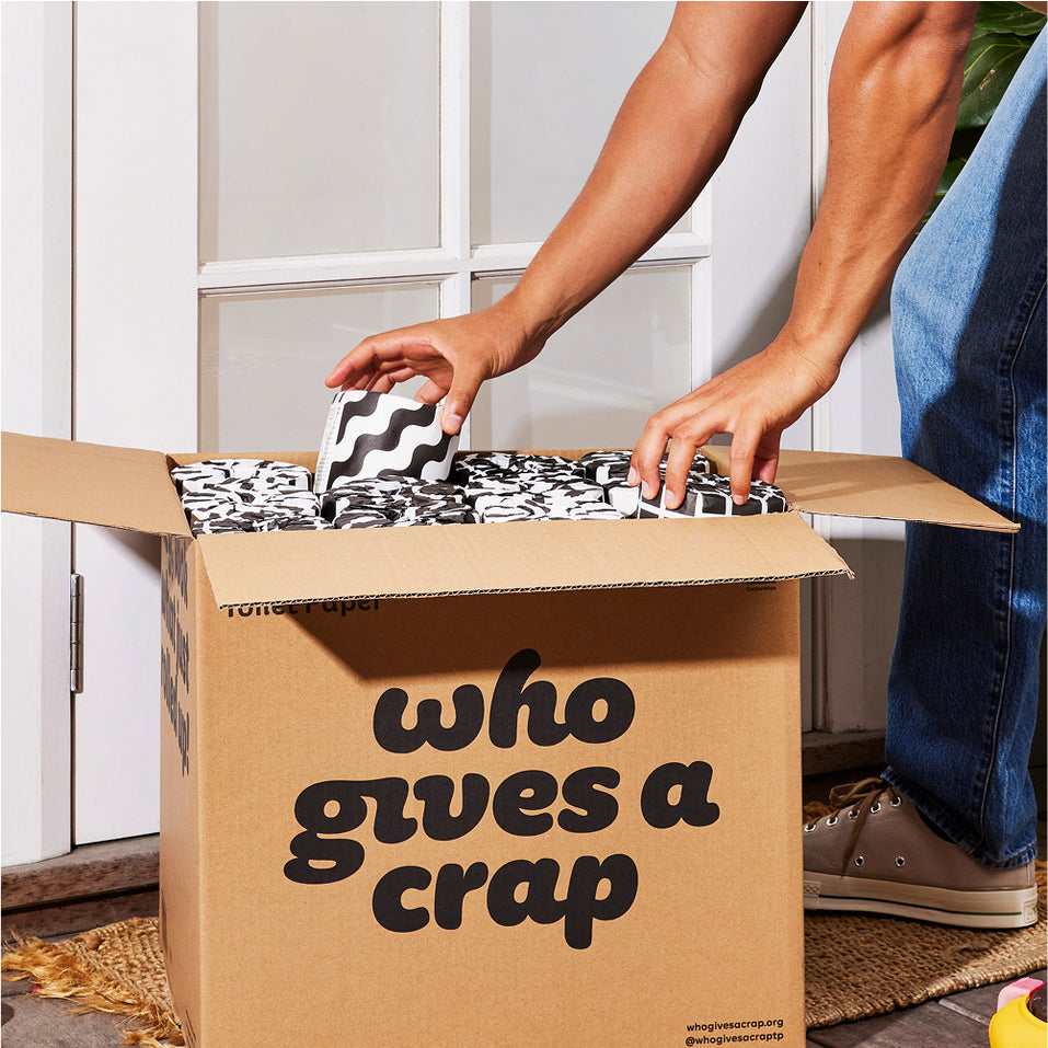 Person at door opening their Who Gives a Crap box of toilet paper.