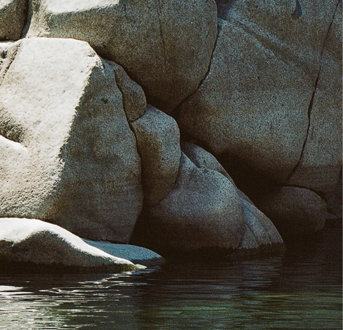 Close up of large rocks surrounded by a body of water