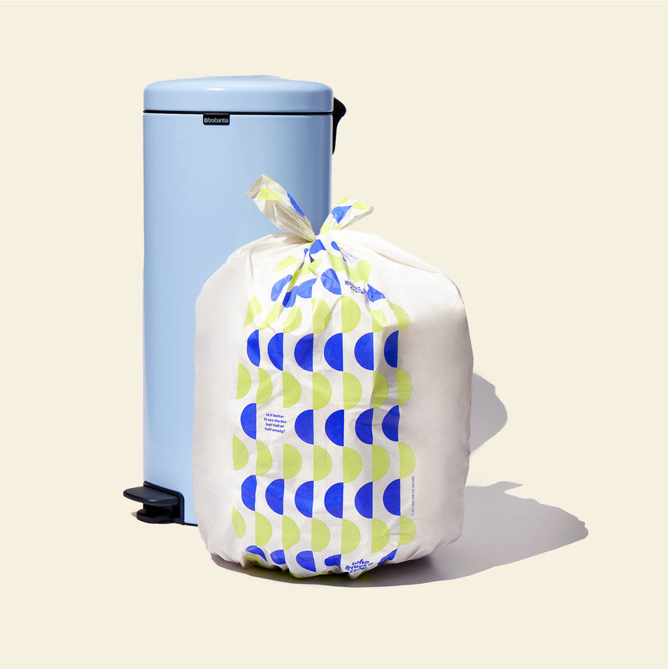 Who Gives a Crap large recycled trash bag sits full next to kitchen bin
